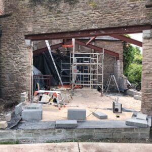 On a construction site, stone walls and steel frame work, extension to a listed building in Herefordshire, communion architects.
