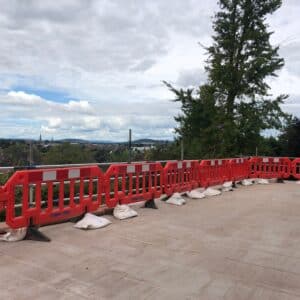 A terrace with red plastic railings around it. The view looks out over Hereford. A terrace for a garden. Communion Architects Hereford.