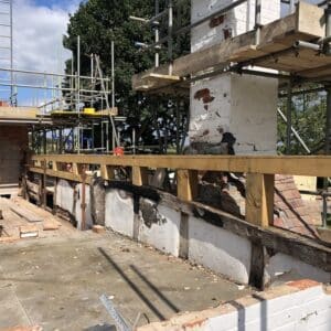 Looking over a roof of a fire damaged thatch cottage, currently being supported by lots of scaffolding, a new oak support has been installed along one side of the roof, this will support the new thatch coming soon. Communion Architects, Herefordshire, Worcestershire