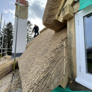 Close up of thatched roof and thatch dormer window. Image focuses on the thickness of thatch which is approximately 50 cm, based on sight. Communion Architects, Hereford, Herefordshire.