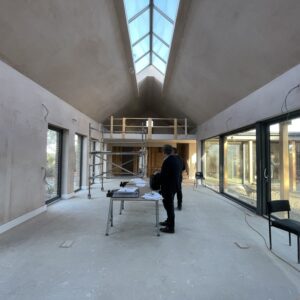 freshly plastered main room interior for a new build in Herefordshire. glazed walls and an apex roof with a full length sky light. communion architects Hereford.