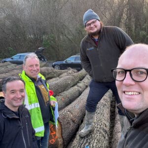 A group of four men viewing felled tree trunks. Communion Architects Hereford